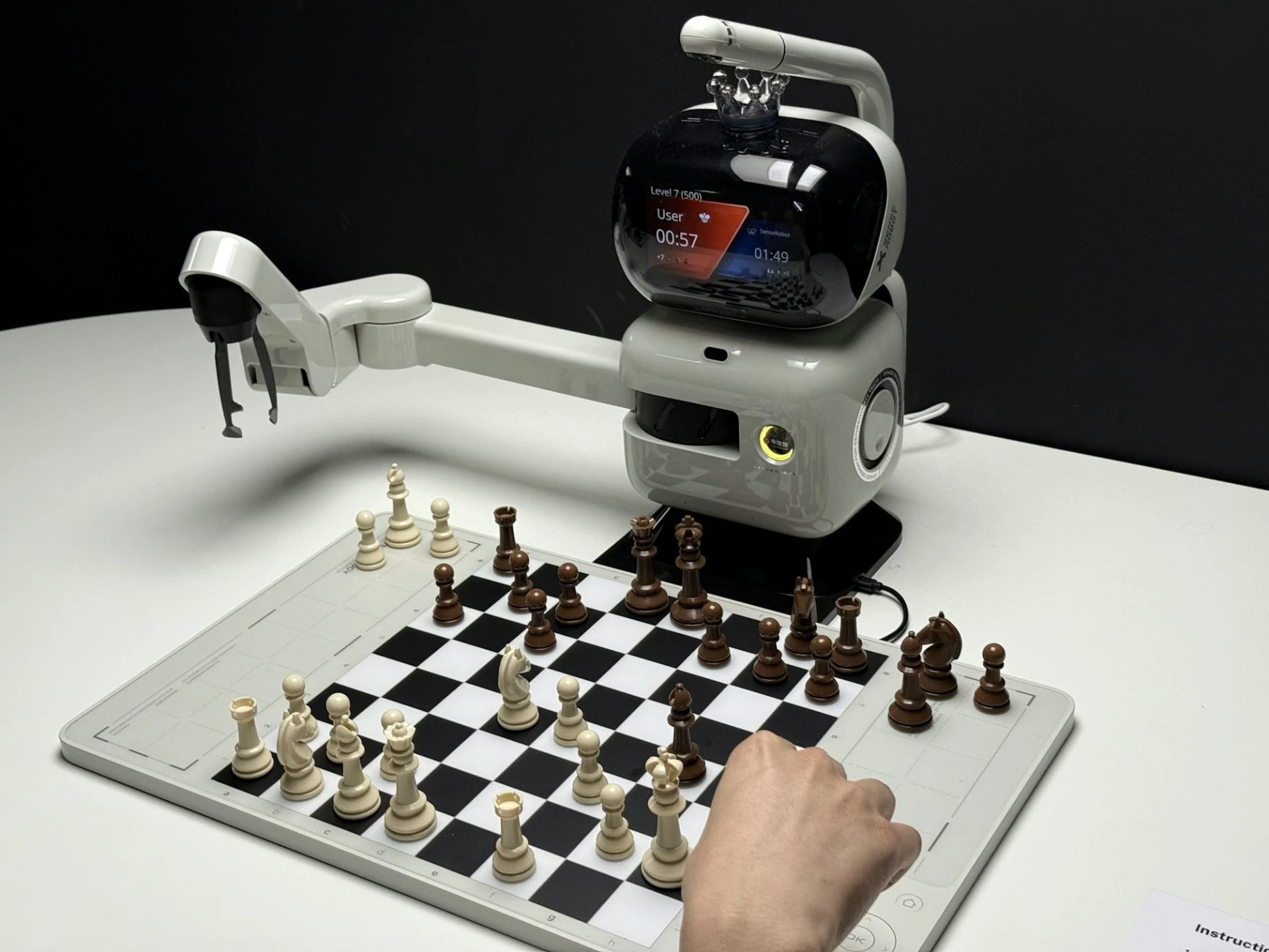 Robot arm playing chess against a human opponent.